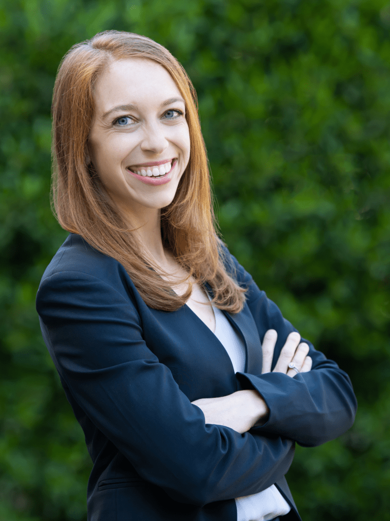 Marlene Goldenberg, Attorney and Partner at Nigh Goldenberg Raso & Vaughn, PLLC, smiling in front of a garden backdrop.