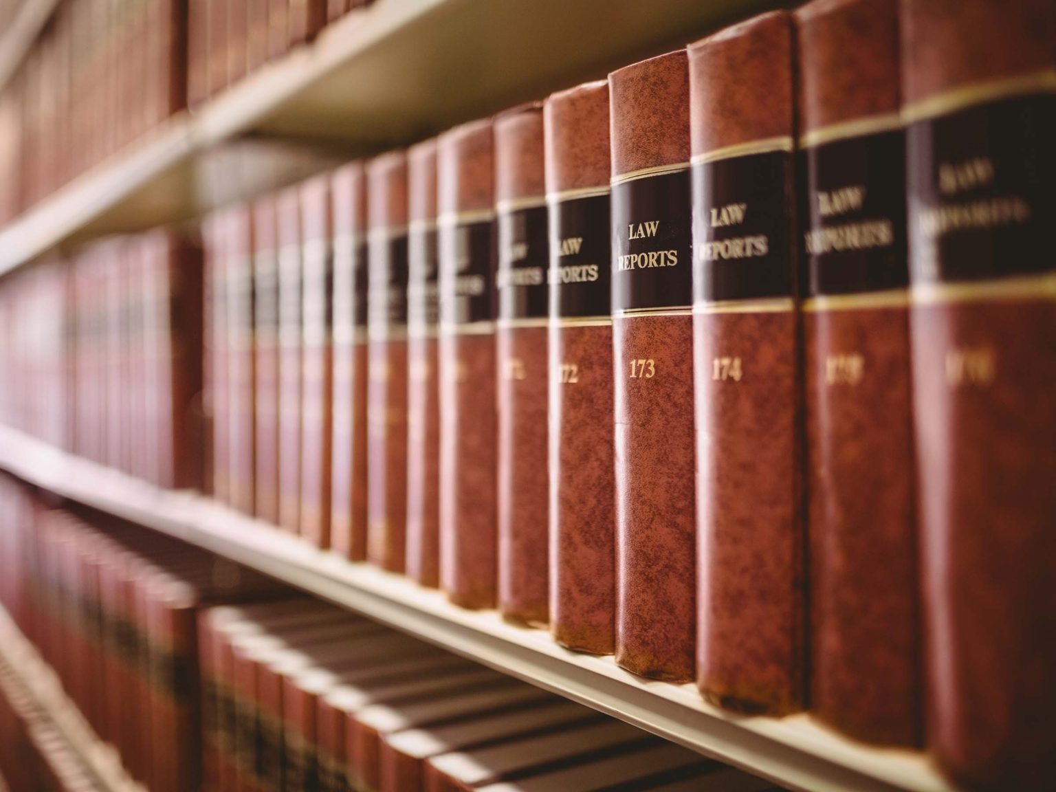 An image of decorative law books and law reports in a library, featuring classic legal literature and history